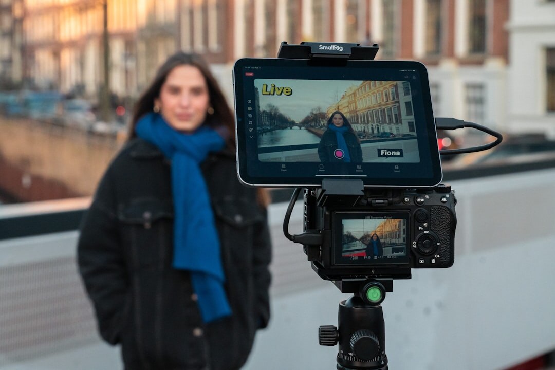 Camera operator filming on a tripod during a field assignment
