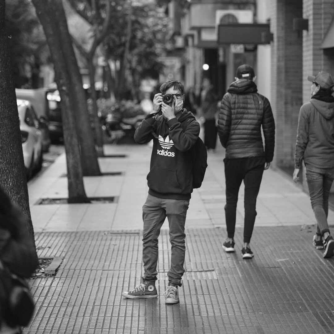 Field reporter holding a professional video camera on an urban street